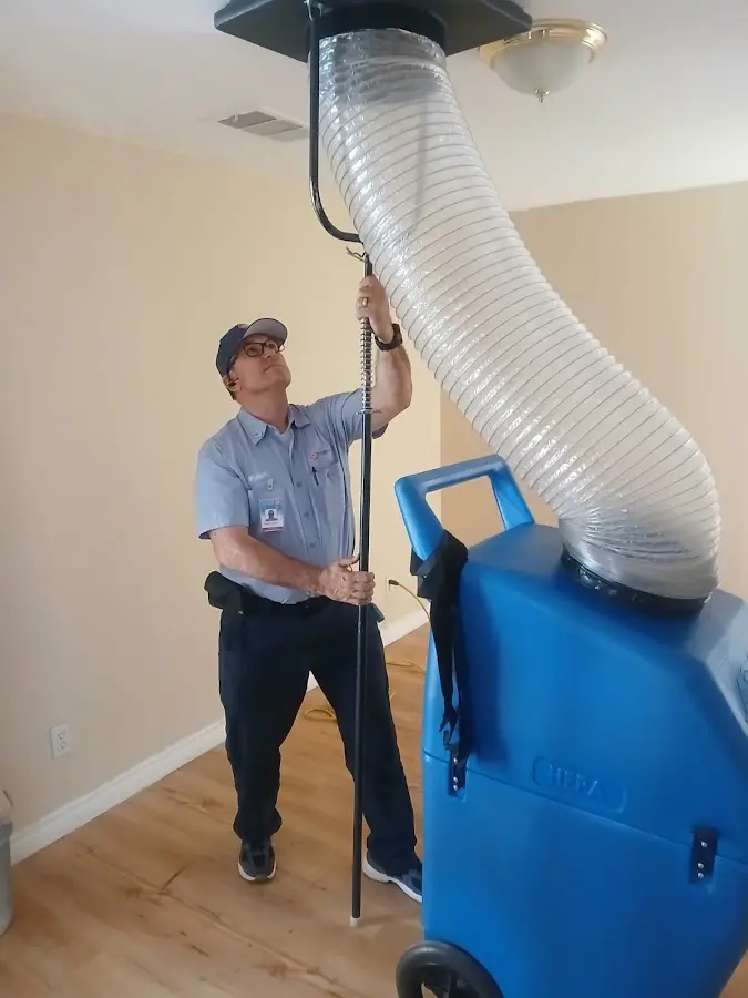 Furnace Tune-Up technician using HEPA equipment in Schriever