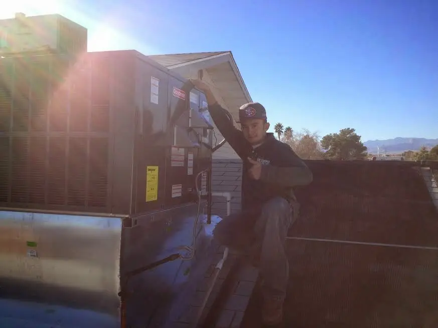 HVAC technician performing Boiler Repair on a rooftop unit in Schriever